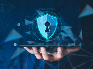A hand holding a laptop with a cyber security graphic floating on top.