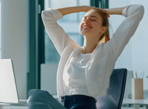 A woman leaning back with relief in an office chair.
