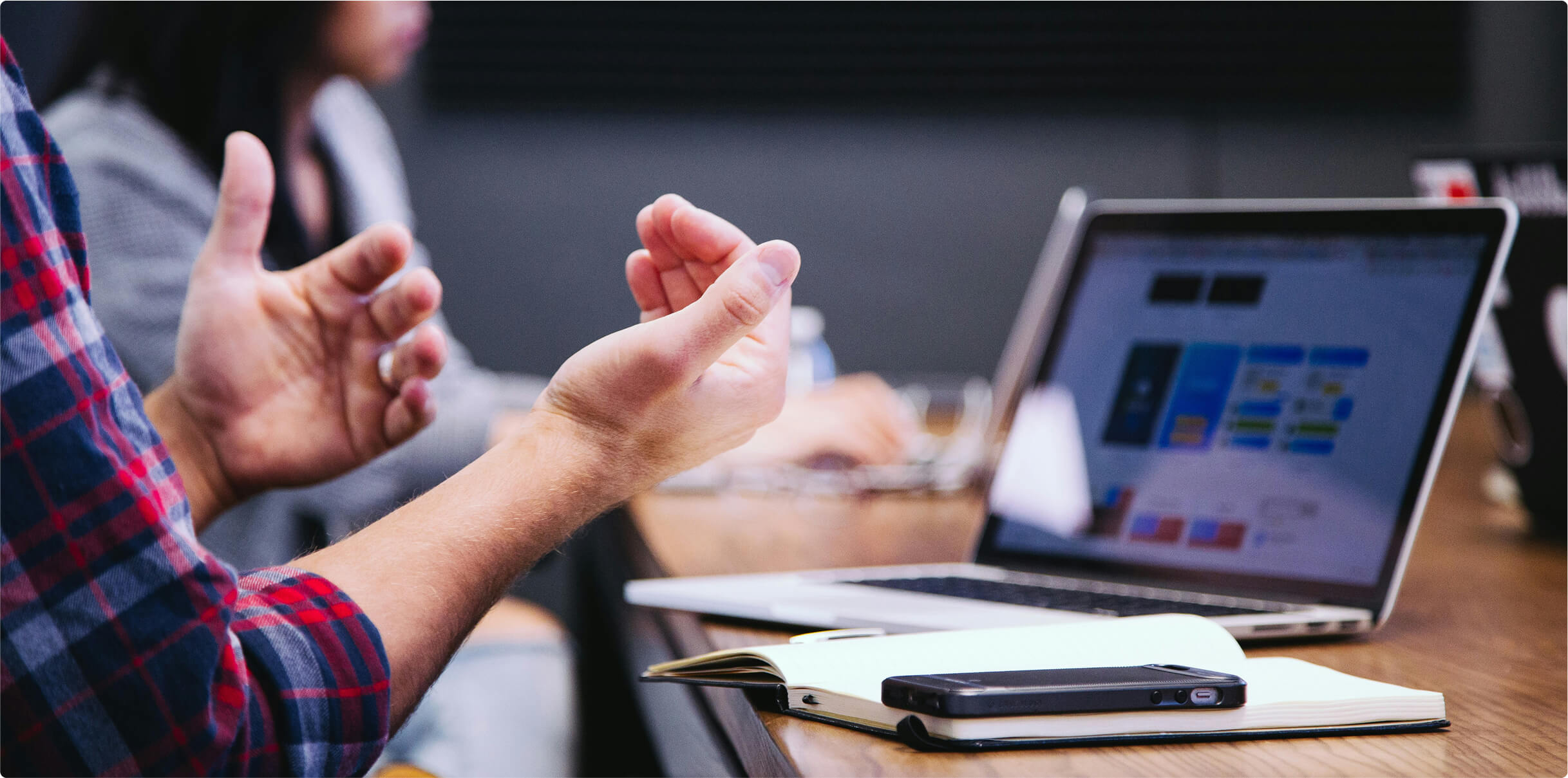 Close up of a persons hands in front of a laptop screen.