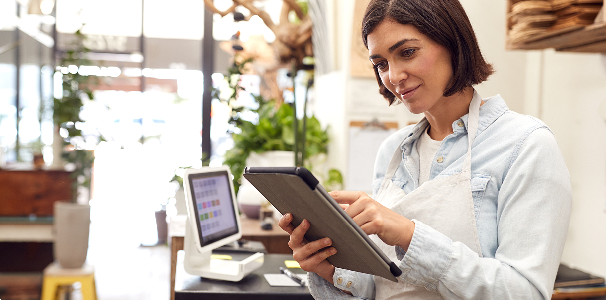 A woman in a retail setting using an iPad to connect to services.