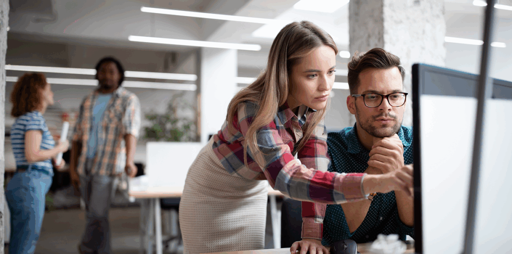 Two coworkers looking at a computer screen.