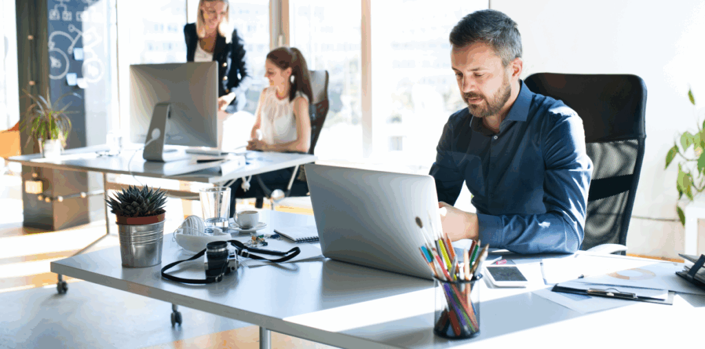 A person working at a laptop in an open office setting.