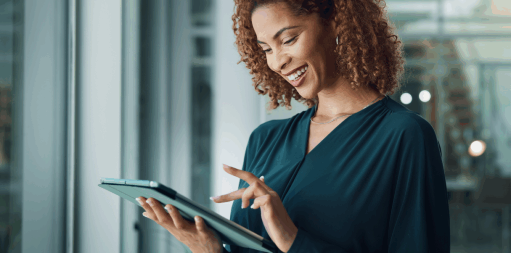 A woman holding an iPad in one hand and touching the screen with the other.