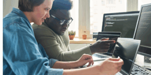 Two coworkers looking at computer screens.