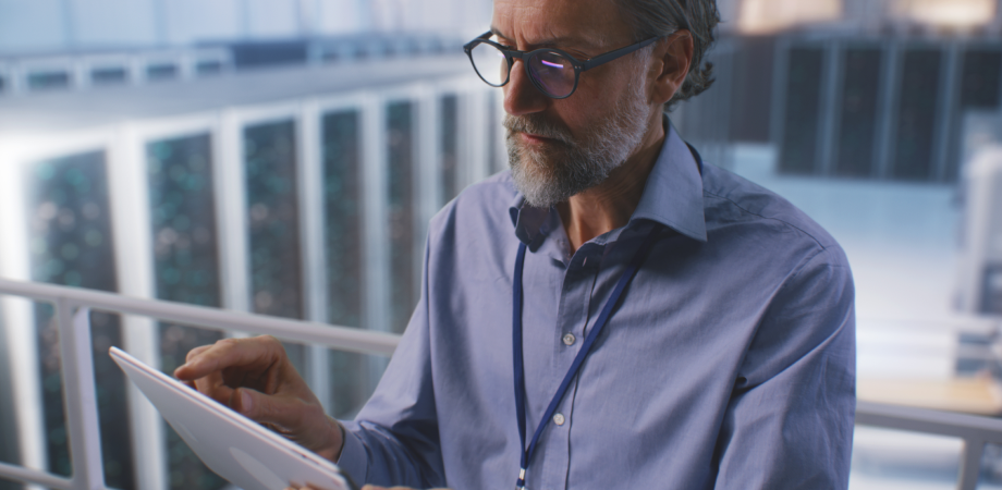 An older man looking down at an iPad screen.