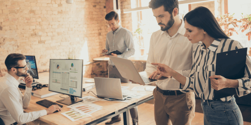 Four people in an open space office working on their computers.