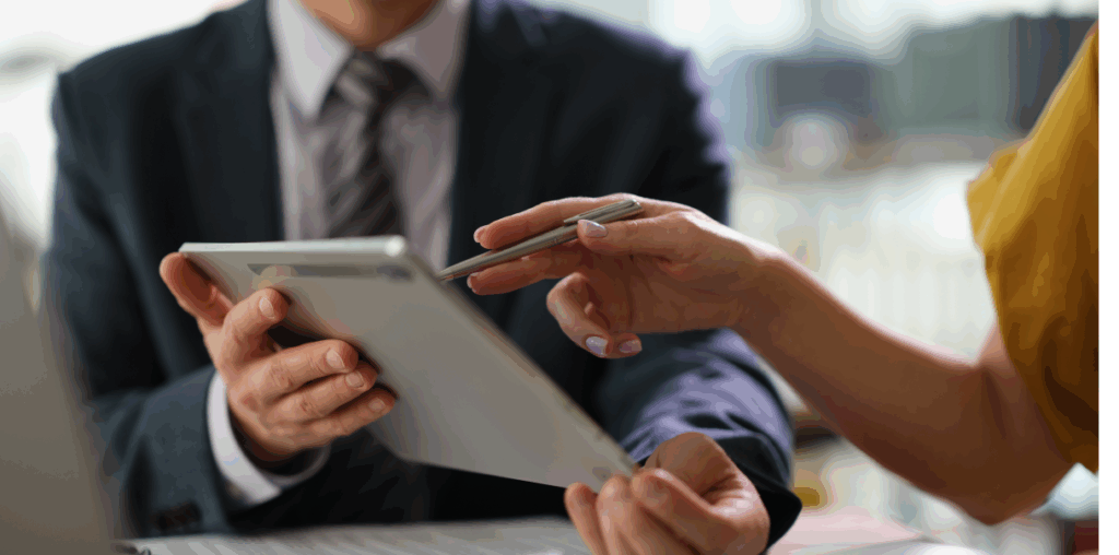 A close up of hands holding an iPad while another hand is holding a stylus and pointing to the screen.