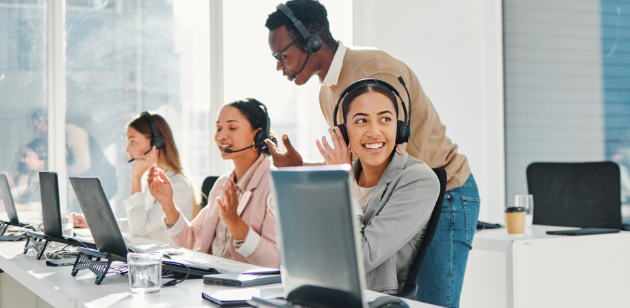 A group of IT support professionals in an open office environment. They are all wearing headsets.