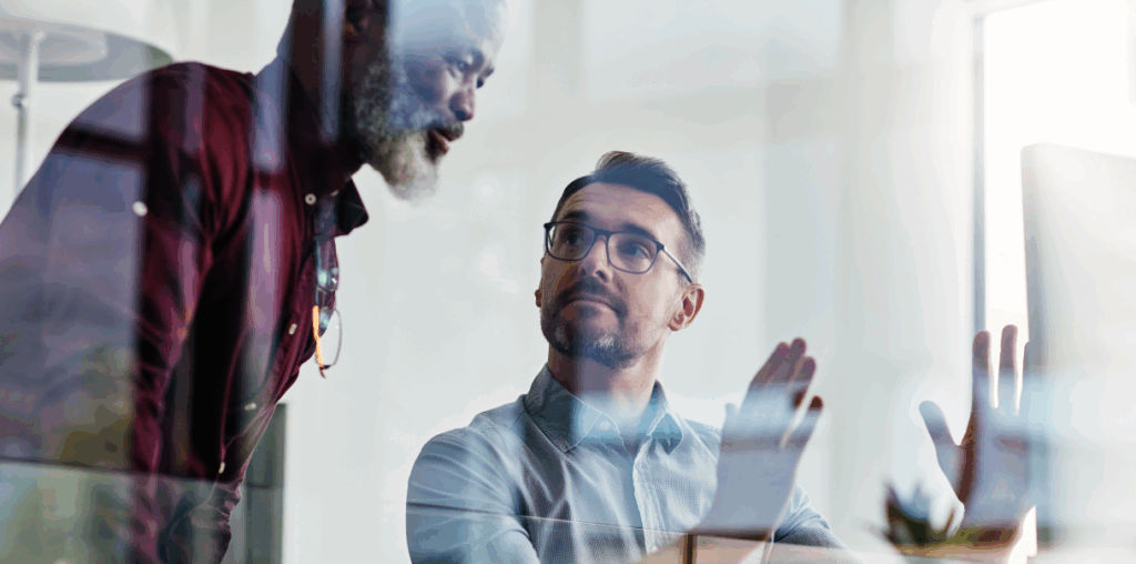 A man explaining a concept to coworker, using his hands to explain.